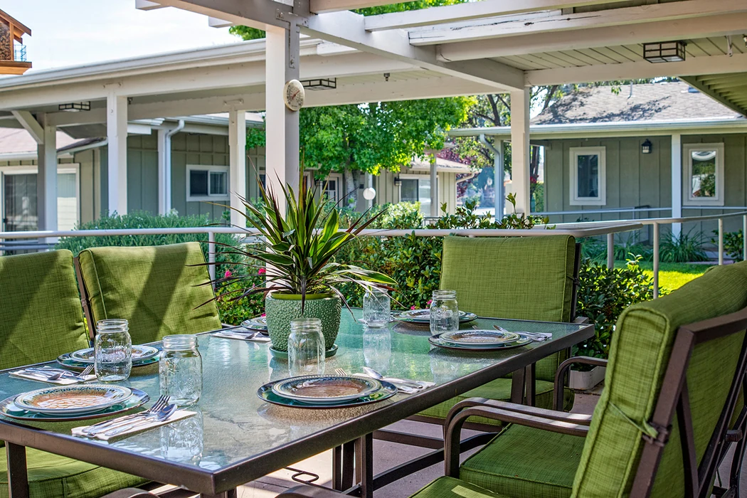 Outdoor dining table on a covered patio at Friendship House